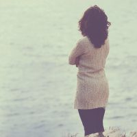 Close-up of a sad and depressed woman deep in thought outdoors. toned image